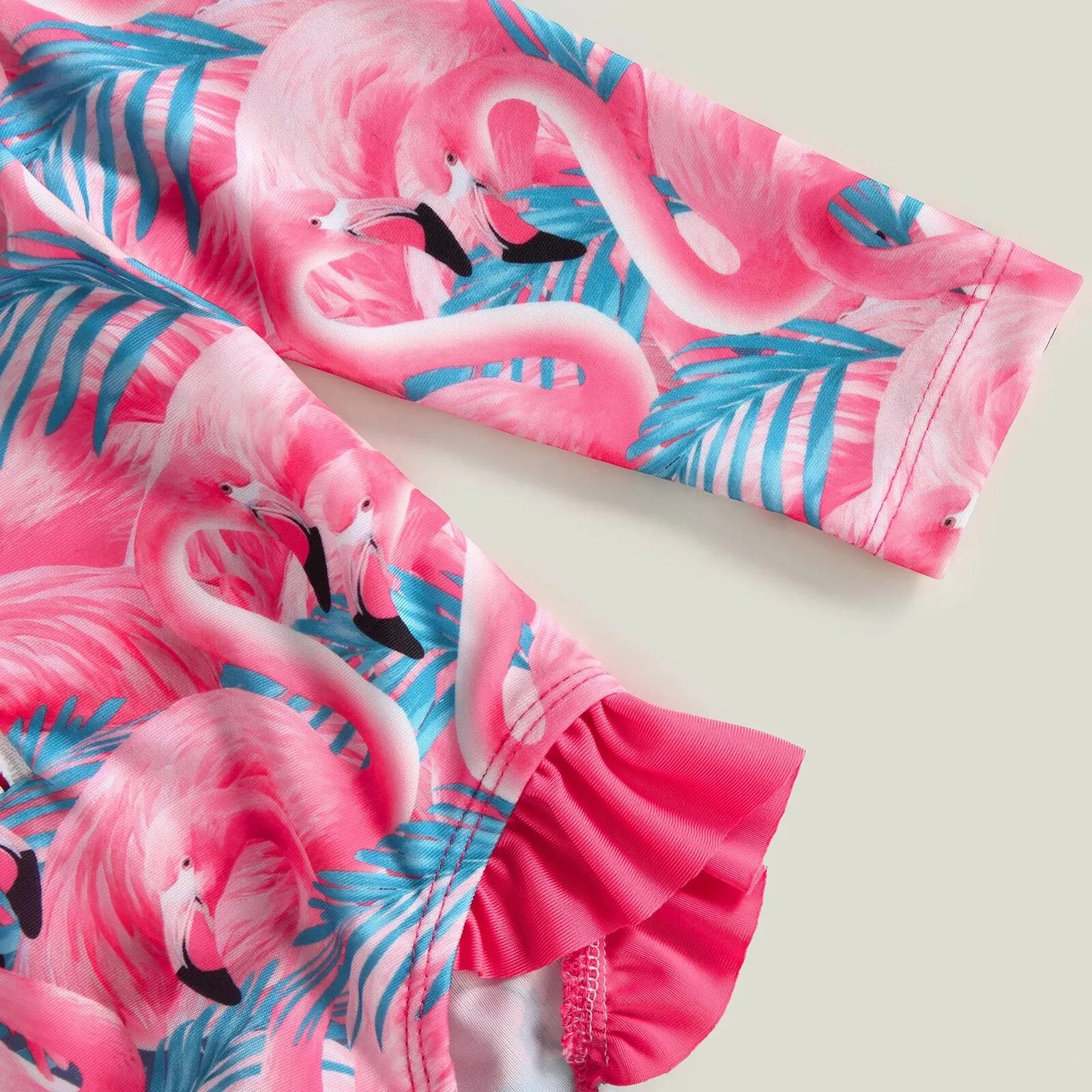 Baby girl one-piece swimsuit with a floral flamingo print from Baby Bubble, featuring colorful tropical design and ruffled straps.