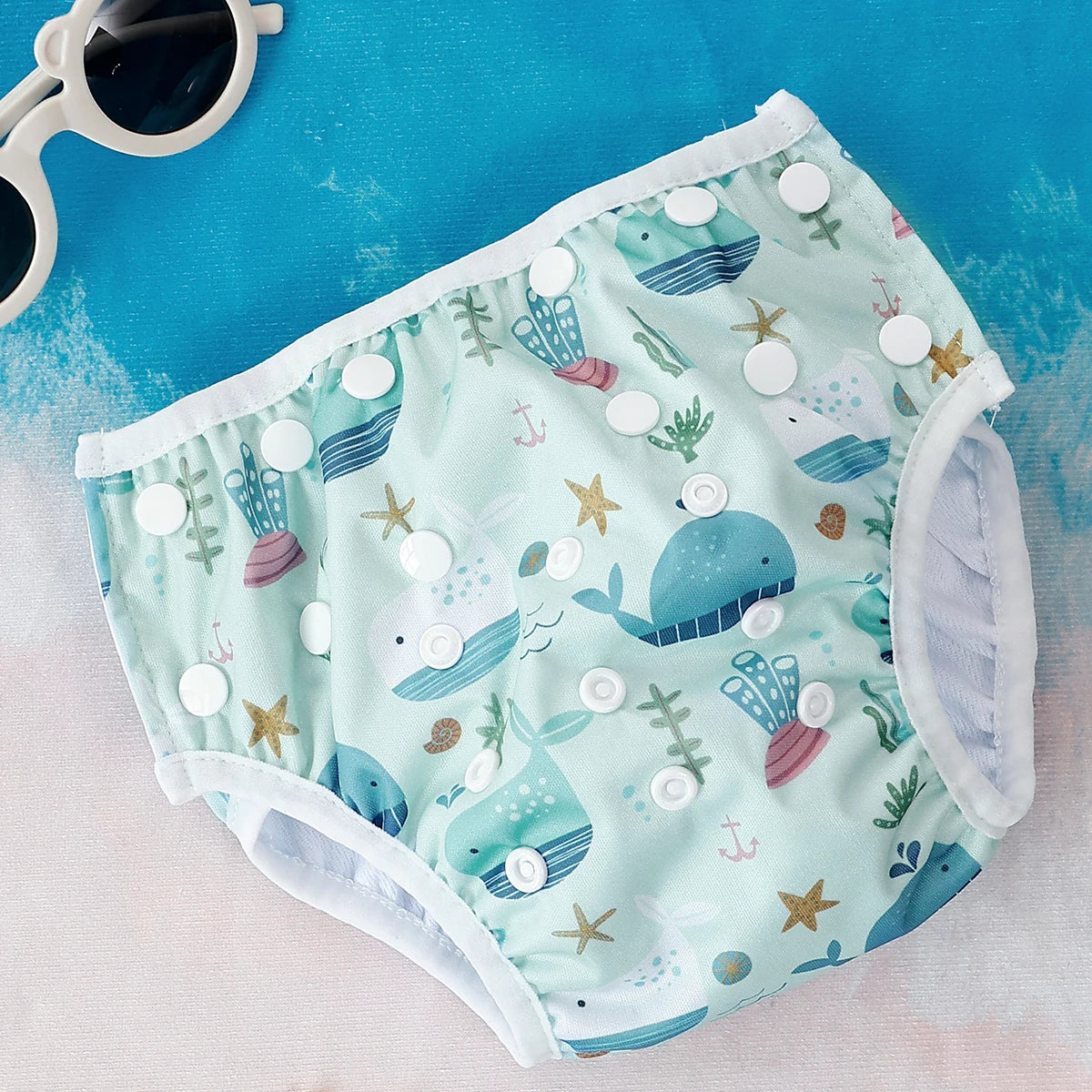 Baby Bubble washable baby swim diapers with adjustable fit, shown in a colorful, reusable design for infants on the poolside.