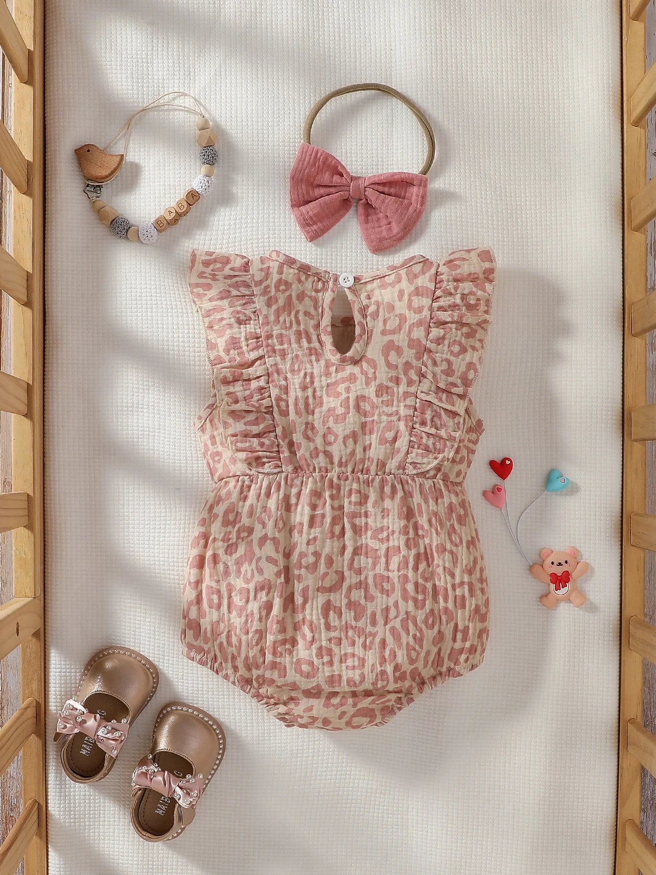 Baby girl summer pink jumpsuit with bow and matching headband, made by Baby Bubble, displayed on a neutral background.