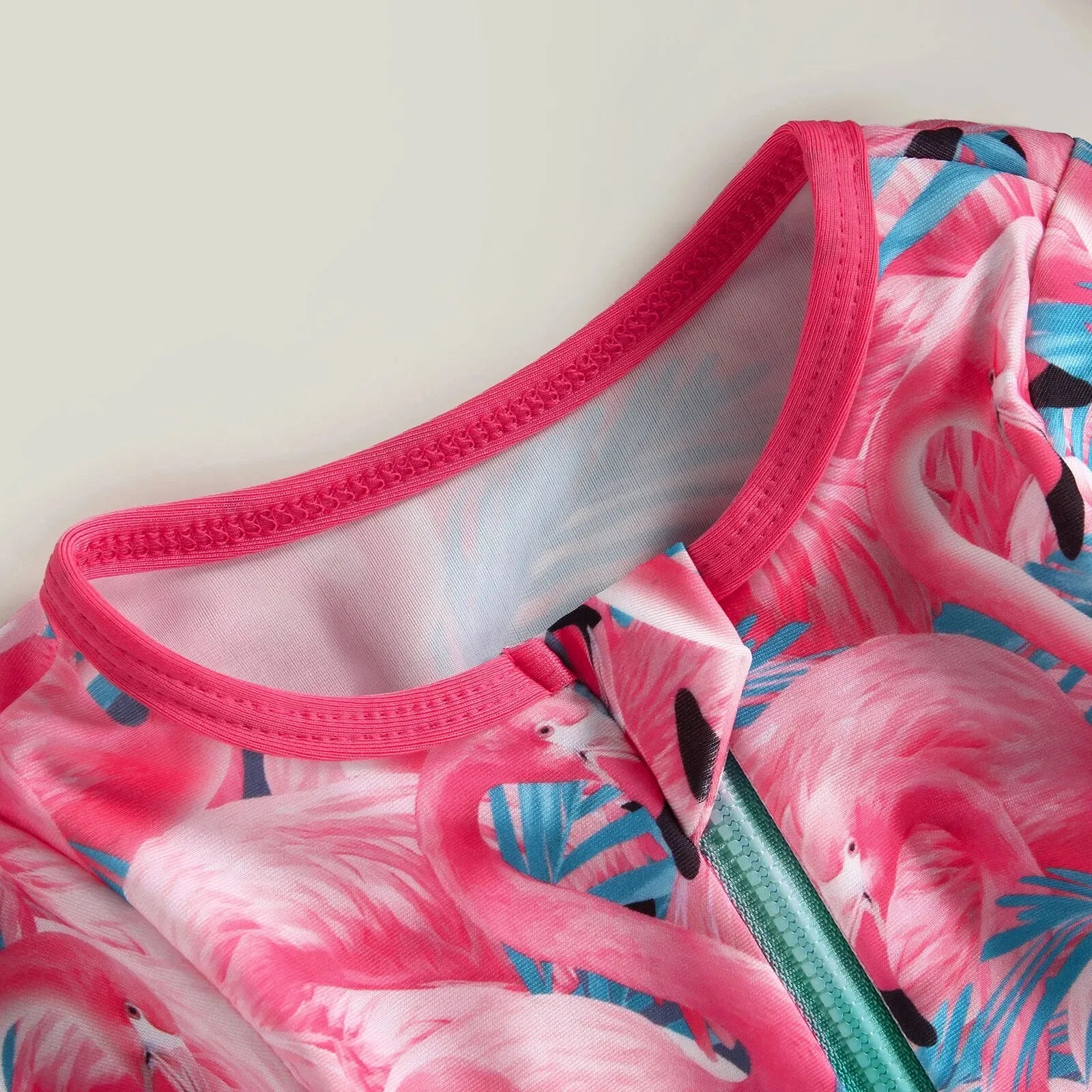 Baby Girl one-piece swimsuit with floral flamingo print by Baby Bubble, featuring bright, colorful tropical design for warm weather swimming.