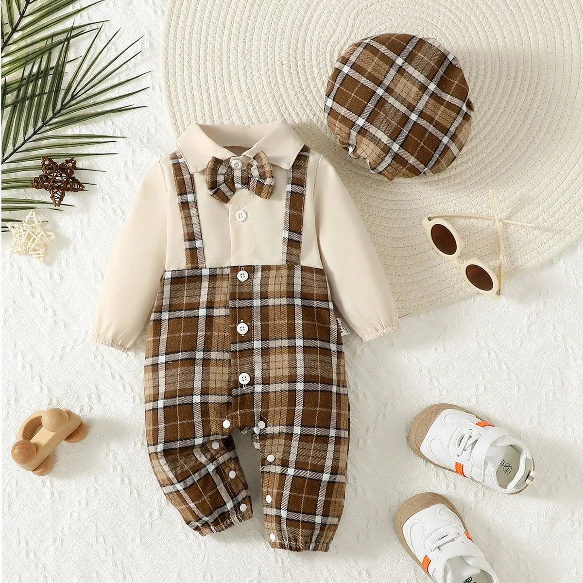 Baby boy in a cute gentleman set with suspenders, jumpsuit, and matching hat, stylishly dressed in Baby Bubble clothing.
