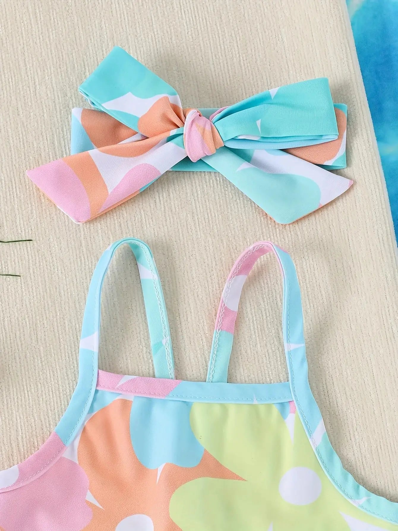 Baby Girls one-piece swimsuit by Baby Bubble featuring colorful patterns, suitable for newborns to toddlers, shown on a baby.
