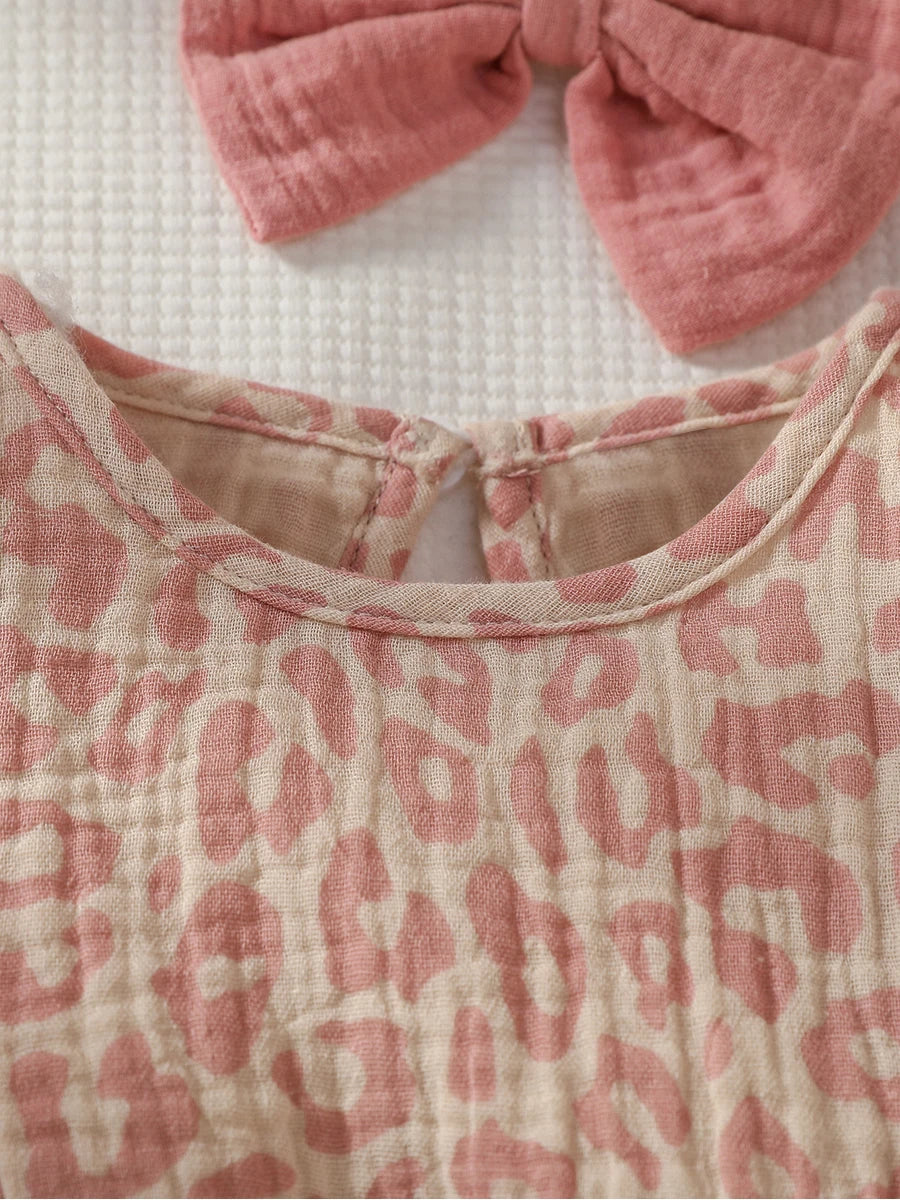 Baby girl summer pink jumpsuit with bow, paired with matching headband, from Baby Bubble. Soft fabric and playful design.