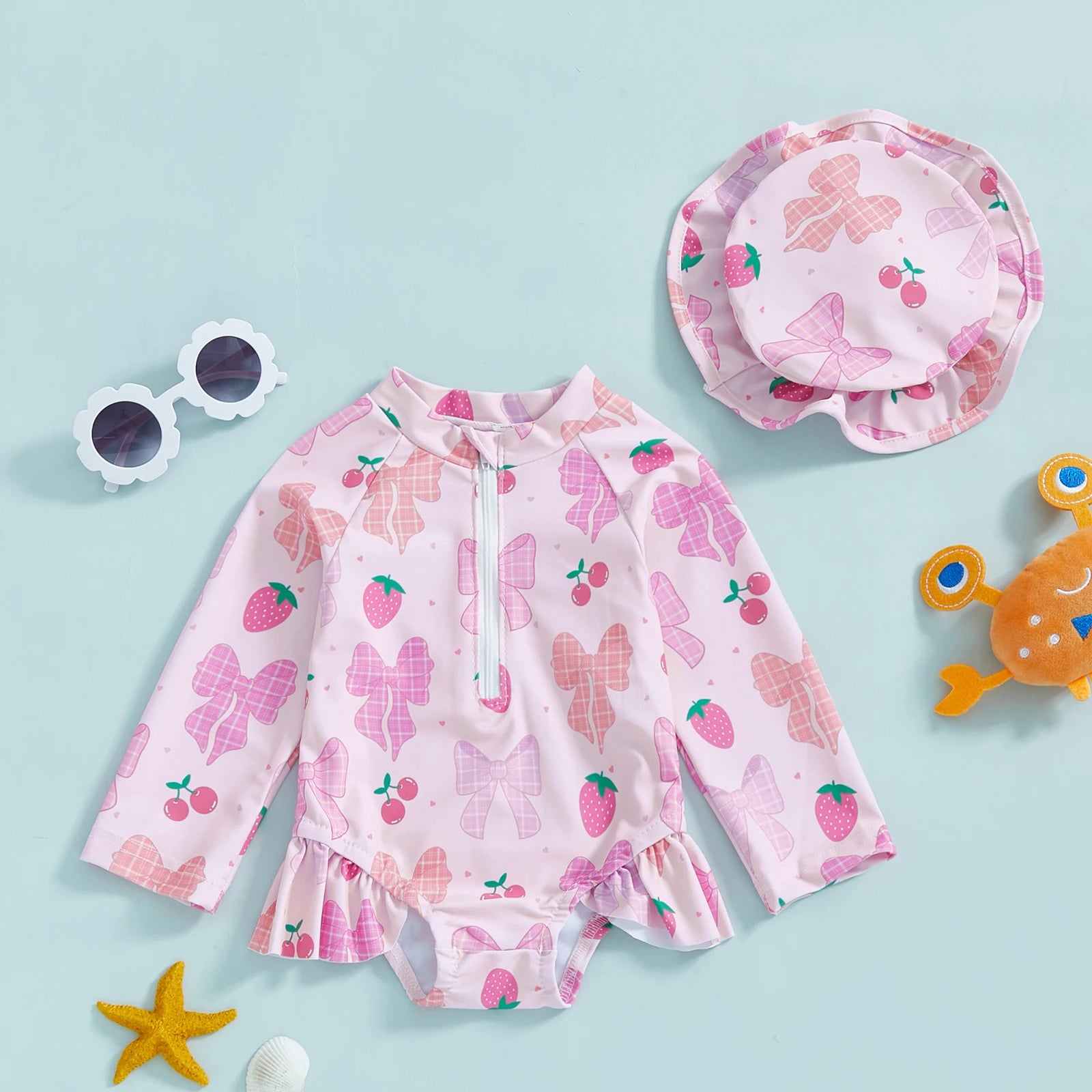 Baby girl wearing a floral rash guard with matching hat, zip-up style by Baby Bubble, suitable for sun protection and outdoor play.