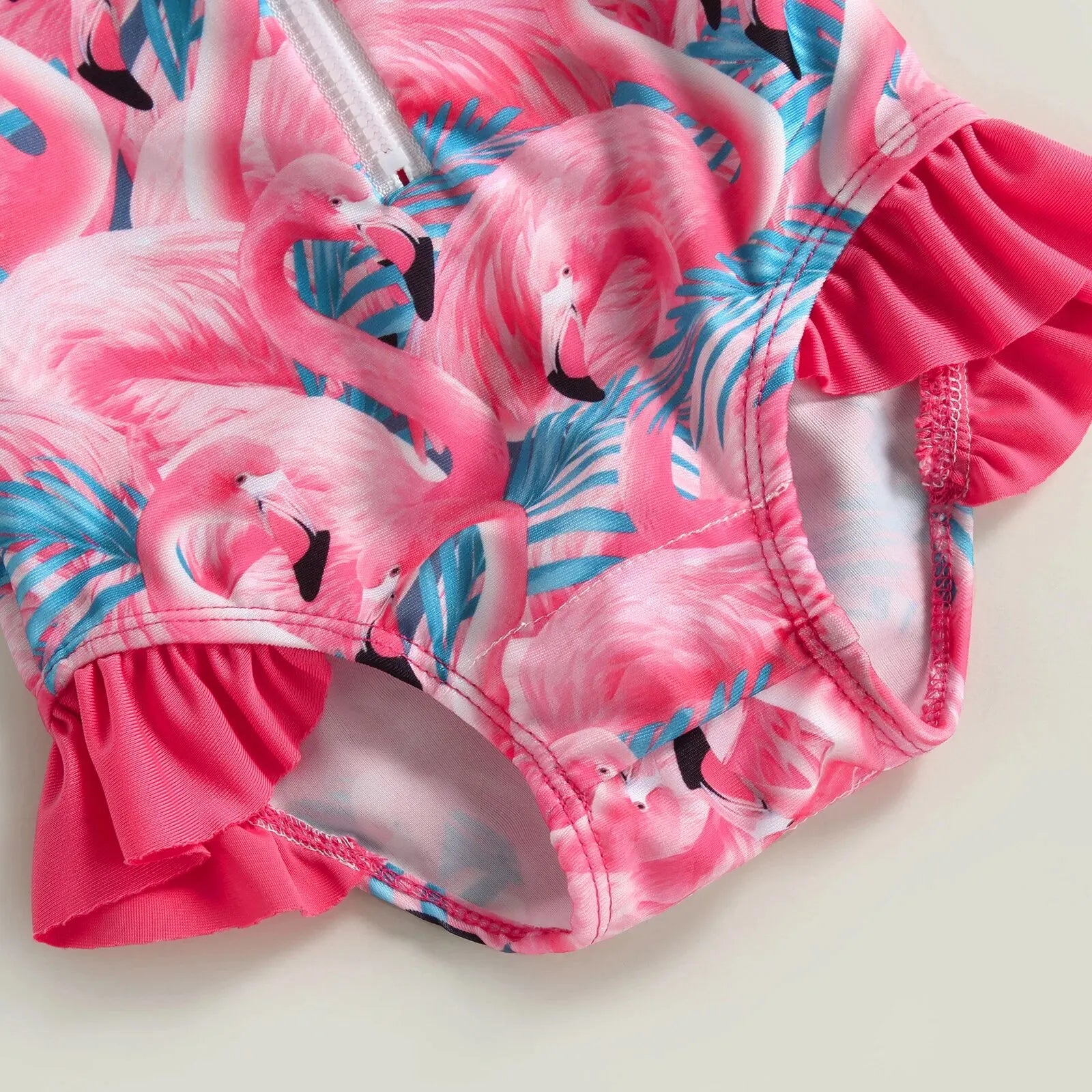 Baby Girl one-piece swimsuit with floral flamingo print by Baby Bubble, featuring colorful flamingos and tropical flowers.
